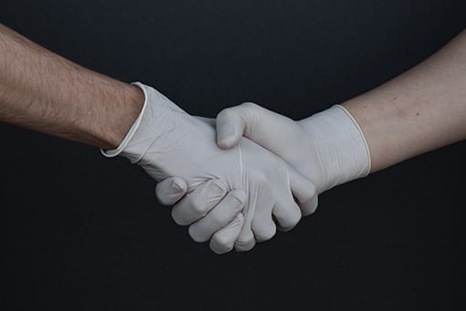 Coronakrise-Einigung-Therapeuten-Physiotherapie-Pixformance-Telemedizin-DVG Händedruck mit Handschuhen: In der Coronakrise greifen viele Therapeuten auf digitale Möglichkeiten zurück.